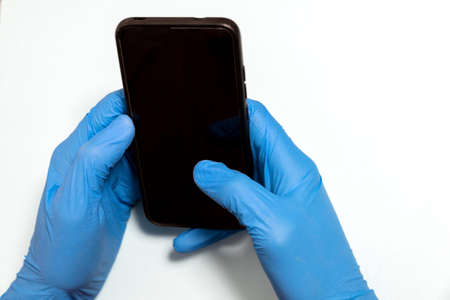 selective focus of a doctor or nurse with blue latex gloves using the mobile phone to communicate make a consultation or workの写真素材