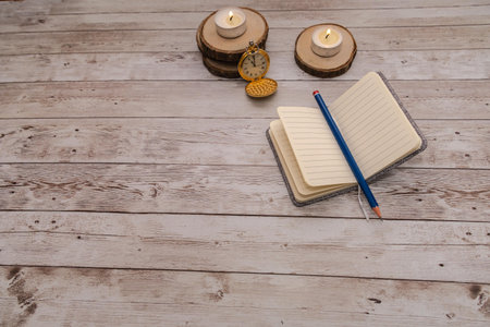 notebook looking for ideas along with lit candles and antique clock with copy space