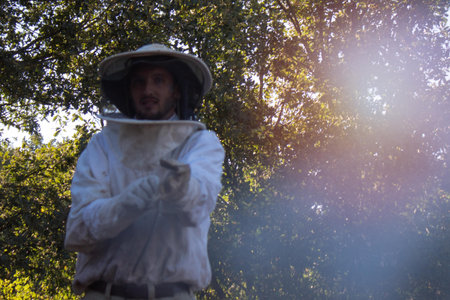 young man putting on his white beekeeper's suit to collect honey from the honeycombs in winter