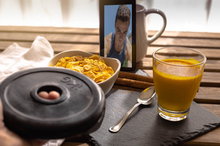 Selective approach person lifting a 1 kg dumbbell and eating cornflakes with turmeric golden milk...