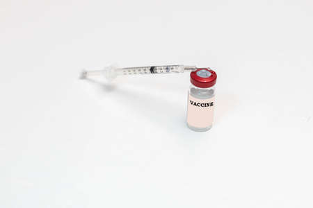 selective focus of a Vaccine and a syringe on a white background as a remedy to the disease viruses and Covid19 in health and pandemic conceptの写真素材