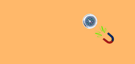 image of a compass and a magnet joined by the north on orange background and copy space concept cheat company north courseの写真素材