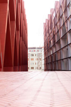 BURGOS, SPAIN - April 9, 2021: Perspective of the street formed by the two buildings of the Museum of Evolution in Burgos, with glass and red rhombus-shaped structure.のeditorial素材