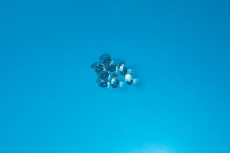 set of transparent medicine capsules on blue background health care concept with copy spaceの写真素材