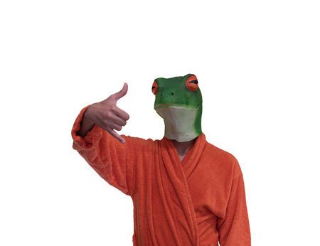 young boy wearing a green frog animal mask with orange bathrobe with surfing hand gesture with pinky and thumb on white background with conceptual copy spaceの写真素材
