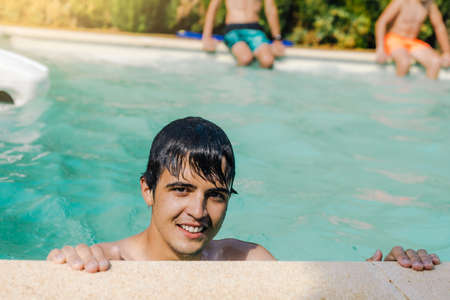 selective focus of a portrait of a Caucasian boy with face and hair wet from swimming pool water on a hot summer day with copy spaceの写真素材
