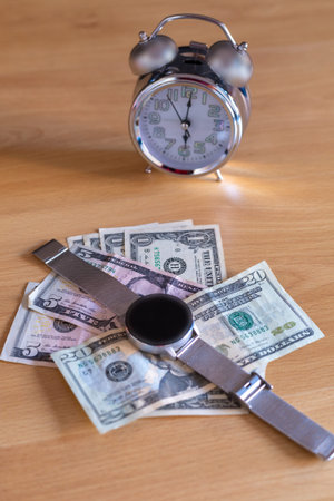 dollar money placed on a table with an analog clock and a digital clock concept time of money