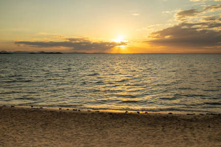 yellow sunset on the beach in the mediterranean sea with sunsetの写真素材