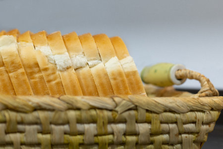 wicker tray with square slices of fresh bread for making toastsの写真素材