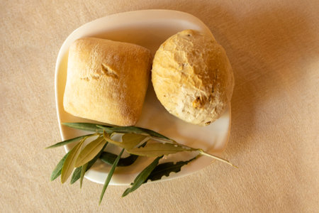 detail from above of square buns with a rosemary leaf to decorate with selective focus