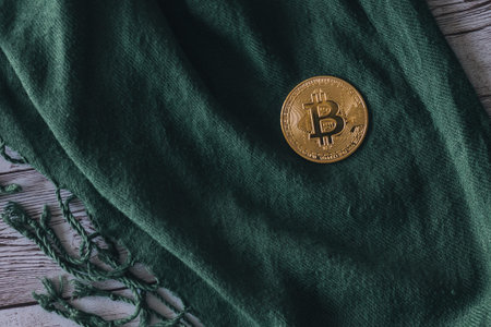 bitcoin coin on a green cloth handkerchief on a wooden table