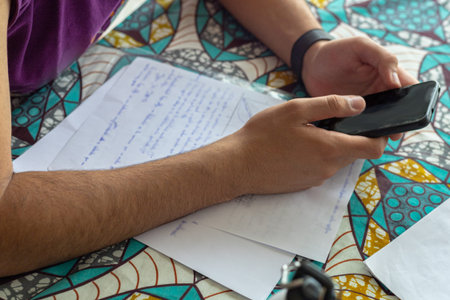 young man studying for the exam and distracted by the mobile phone