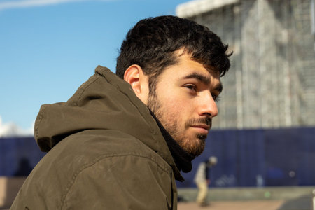 young adult portrait with short beard of fashion model with restrained look and smile