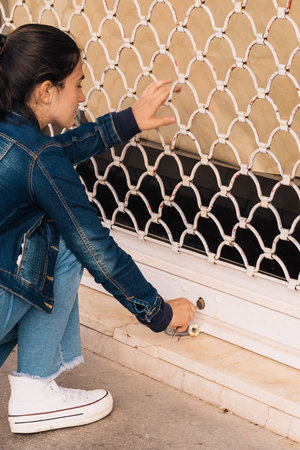 young businesswoman girl closing the cock of her business to put an end to the activity due to the economic crisisの写真素材