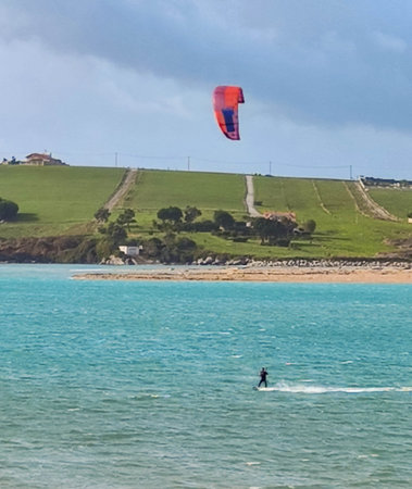 person enjoying a wonderful day kitesurfing on the beach on a sunny summer day