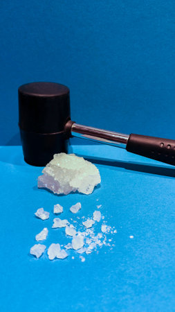 vertical photo of a sodium chloride mineral or common salt hit with a hammer leaving smaller particlesの写真素材