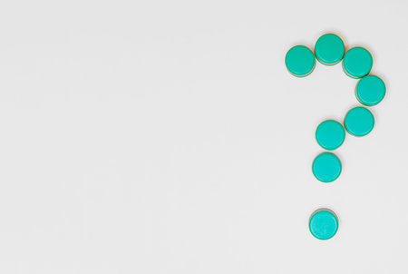 plastic bottle caps in the shape of a question mark with copy space on a white background concept...