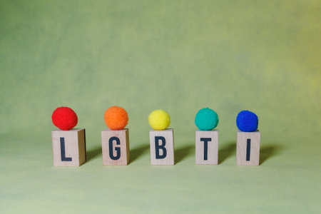 LBGTI word constructed by wooden letters on a yellow background with balls in the colors of the lbgti flag to indicate a concept.の写真素材