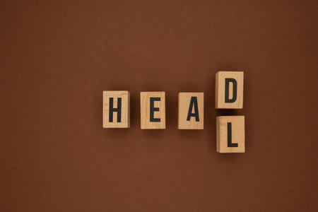 Wooden blocks on brown background forming the words HEAD and HEAL, concept of thinking and recovery.の写真素材