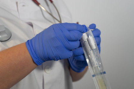 Nurse opening the saliva test for the coronavirus. This test is the first step in verifying that a...