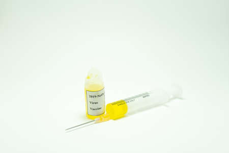 In the foreground the coronavirus vaccine next to a syringe. This will be the cure for 2019-Ncov. This disease is affecting people around the world. In Europe the most affected countries are Italyの写真素材