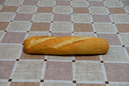 loaves of bread on a table with checkered tablecloth. The bread is freshly baked.の写真素材
