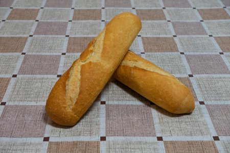 loaves of bread on a table with checkered tablecloth. The bread is freshly baked.