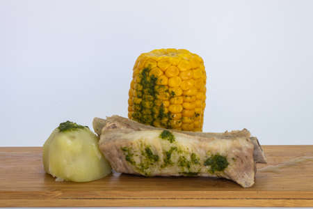 Potatoes, pineapples and ribs, a typical dish from the island of Tenerife. The potatoes, pineapples and ribs are accompanied by a green mojo. The green mojo is coriander. Tipical from canary islands.の写真素材