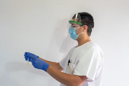 Doctor / Nurse with face shield has a nasal smear for the covid19. Nasal mucus test for viral...