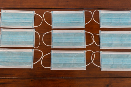 Many blue surgical masks on a table.