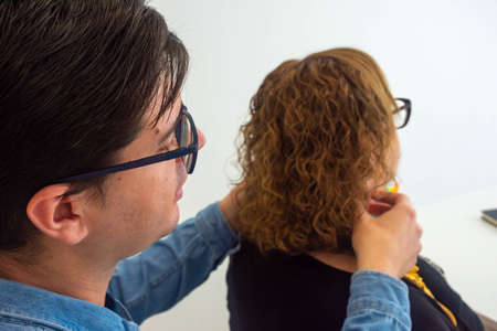 Speech therapist attending to a patient in her office. He's giving her a facial massage.の写真素材