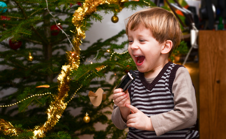 Two-year-old boy feeling excited for the harp he got for Christmasの写真素材