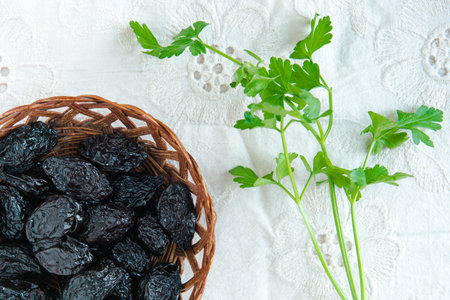 Group of prunes (dried plums) on a white tablecloth, shot from above