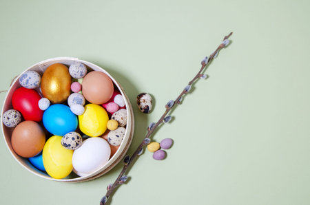 Easter eggs of different sizes: chicken, quail, small candies in the shape of eggs lie in a wooden...