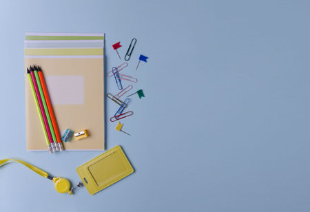 Notebooks, pencils, markers and other stationery lie on a blue background. Concept back to school, goods for school, office, flat layout, space copying, selective focusの写真素材