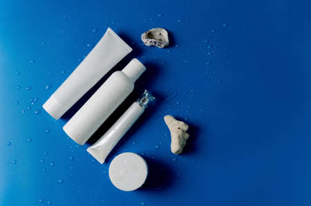 White plastic containers to represent different cosmetics for the care of the face, hands, eyelids, eyes, body, flat layout, copying spaceの写真素材