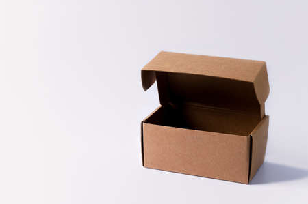 Open box empty inside from brown cardboard on a light background. Box for packaging and delivery of goods, copy spaceの写真素材