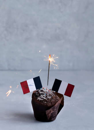 Chocolate cupcake, mafia with French flags and Bengali fire. Bastille Day, public holiday June 14 in Franceの写真素材