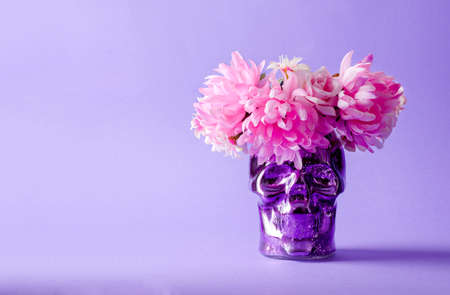 Decorative background for the holiday Dia de Muertos. Decorative colored skull with a wreath on a purple background, selective focus, copying spaceの写真素材