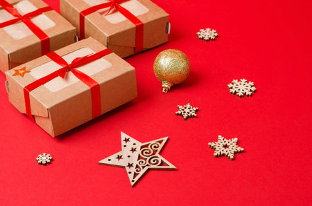 Craft boxes and decorative wooden Christmas tree toys on a red background. Christmas background....
