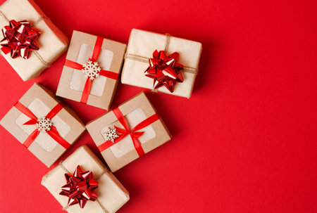 Christmas, New Year's background. Gifts in kraft paper and kraft boxes with red ribbon and bows on a...