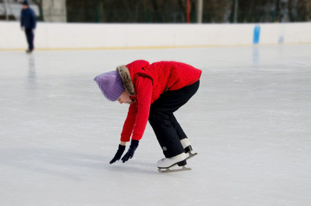 A schoolgirl girl is learning to skate on her own. Soft, selective focusの写真素材