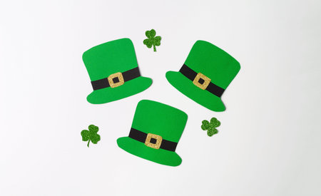Lapricon's paper hats and clover leaves on a white background. Creative festive background of St....