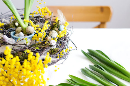 Easter composition with Easter wreath, eggs and spring flowers in the interior, selective focus,...