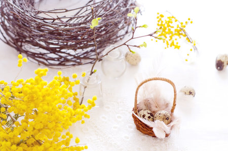 Easter composition. Small eggs in a basket, in the background a blurred wreath of natural twigs and...