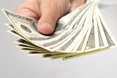 Hand holds several banknotes on a white background. The concept of payment, exchange, savings,...