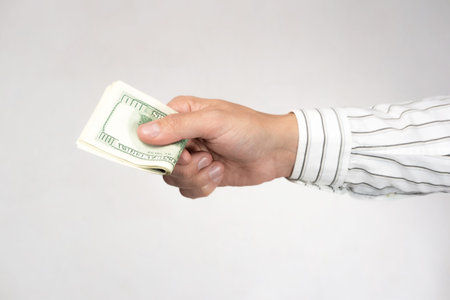 Hand with money on a gray background. The concept of payment, currency exchange, bribery.