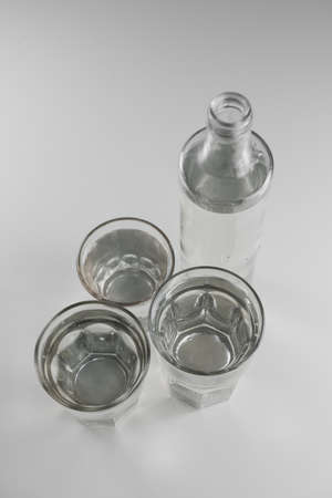Several glasses and a bottle of clean water on a white backgroundの写真素材