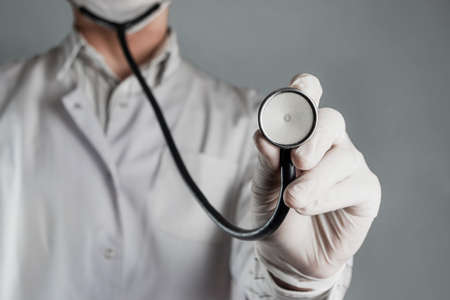 The doctor holds a stethoscope in his hand close-up. The concept of health monitoring, prevention of heart and other diseasesの写真素材