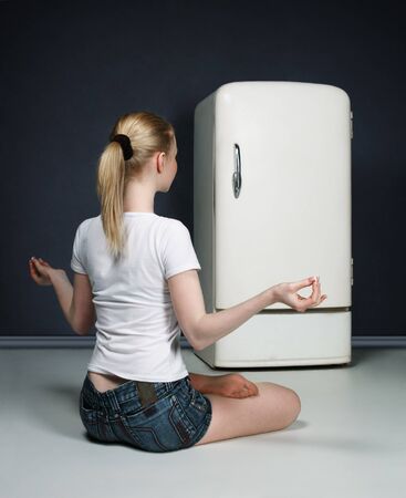 Young slim girl meditating against closed fringeの写真素材
